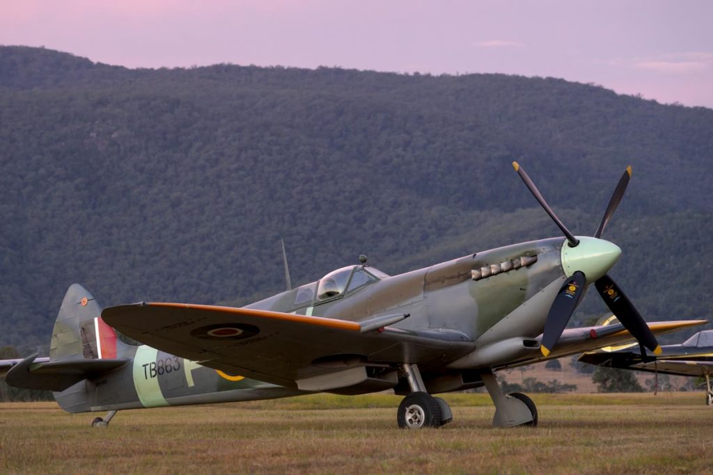 Supermarine Spitfire Mk XVI VH-XVI parked on the airfield at dusk with a colourful sky.