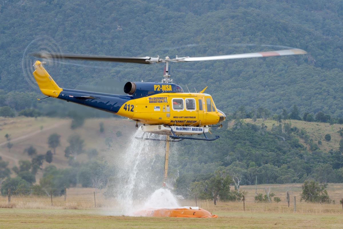 Bell 214B-1 P2-MSA operated by McDermott Aviation. It is configured as a water bomber, in this shot it is filling the water reservoir from a temporary pool.